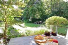 Blick-vom-Esstisch-auf-der-Terrasse-zur-Bank-unter-dem-Nussbaum